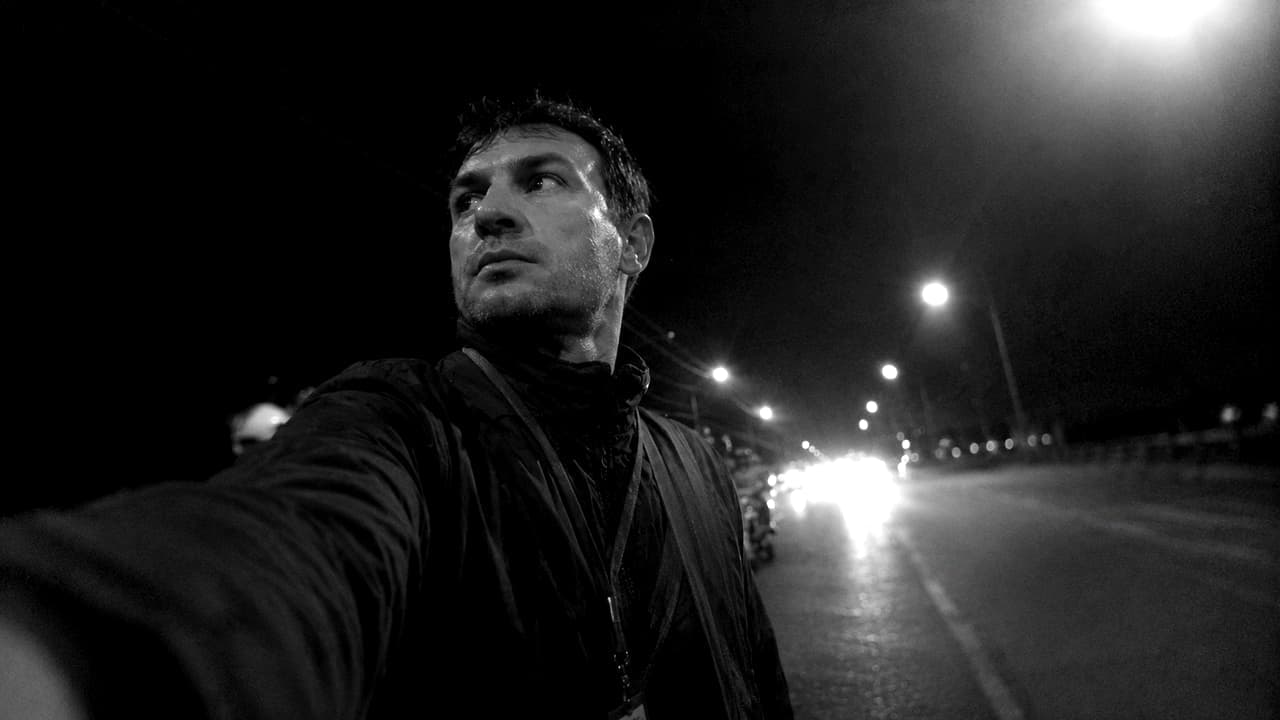 Still from the front camera clip: the person holding the phone, arm out, looking away from the lens at the road